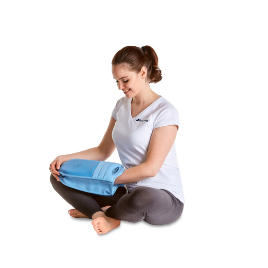 Frau sitzt entspannt und verwendet den blauen Biomag AL14P Magnetfeldtherapie Applikator für die Handbehandlung.