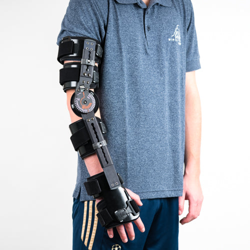 Frontale Aufnahme der schwarzen T-CHECK Ellenbogenorthese, Arm leicht nach vorne gehalten, Person in blauem Poloshirt.