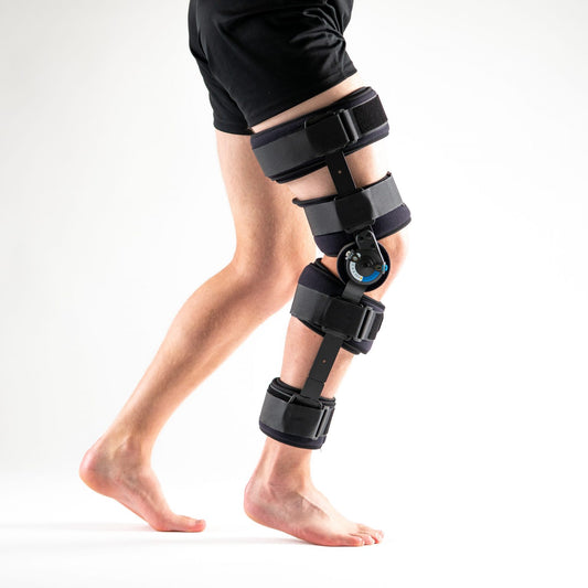 FORMFIT Post-Op Knieschiene in Schwarz am rechten Bein, Seitenansicht, stehend