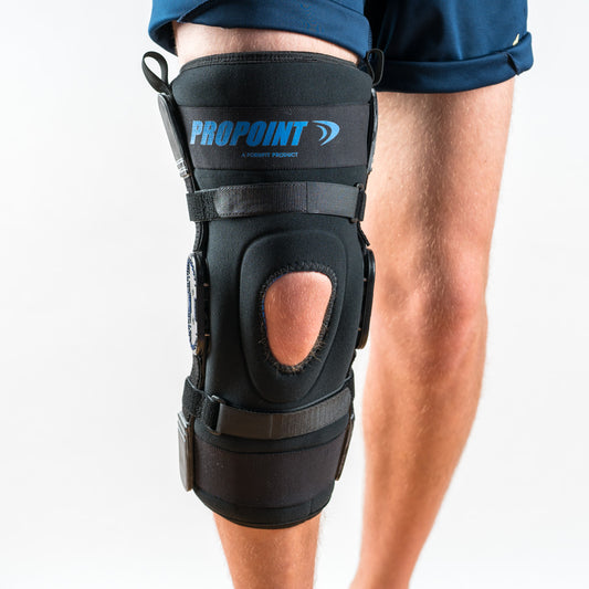 Propoint Knieorthese in Schwarz am rechten Bein, Vorderansicht, stehend