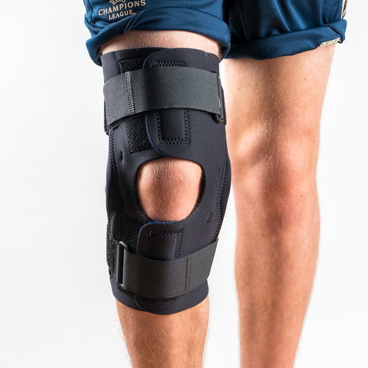 Wrap Around Kniebandage in Schwarz am rechten Bein, Vorderansicht, stehend