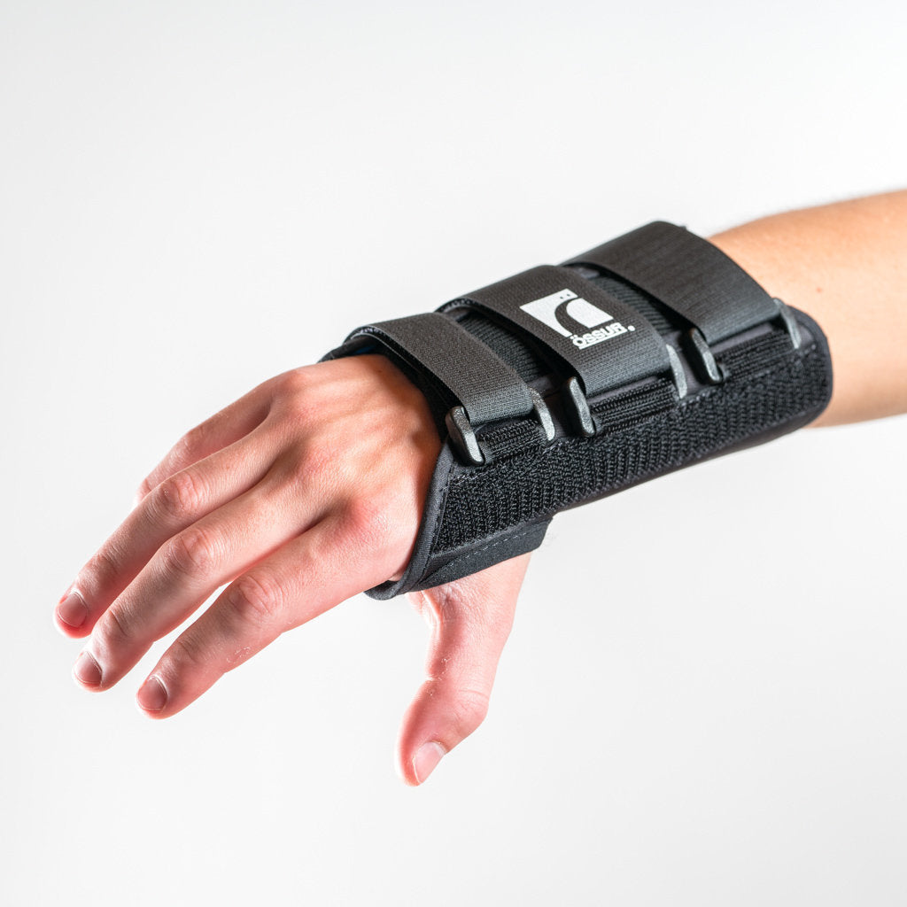 Formfit Handgelenkschiene in Schwarz, Arm leicht nach vorne gestreckt, Hand entspannt nach unten geneigt.