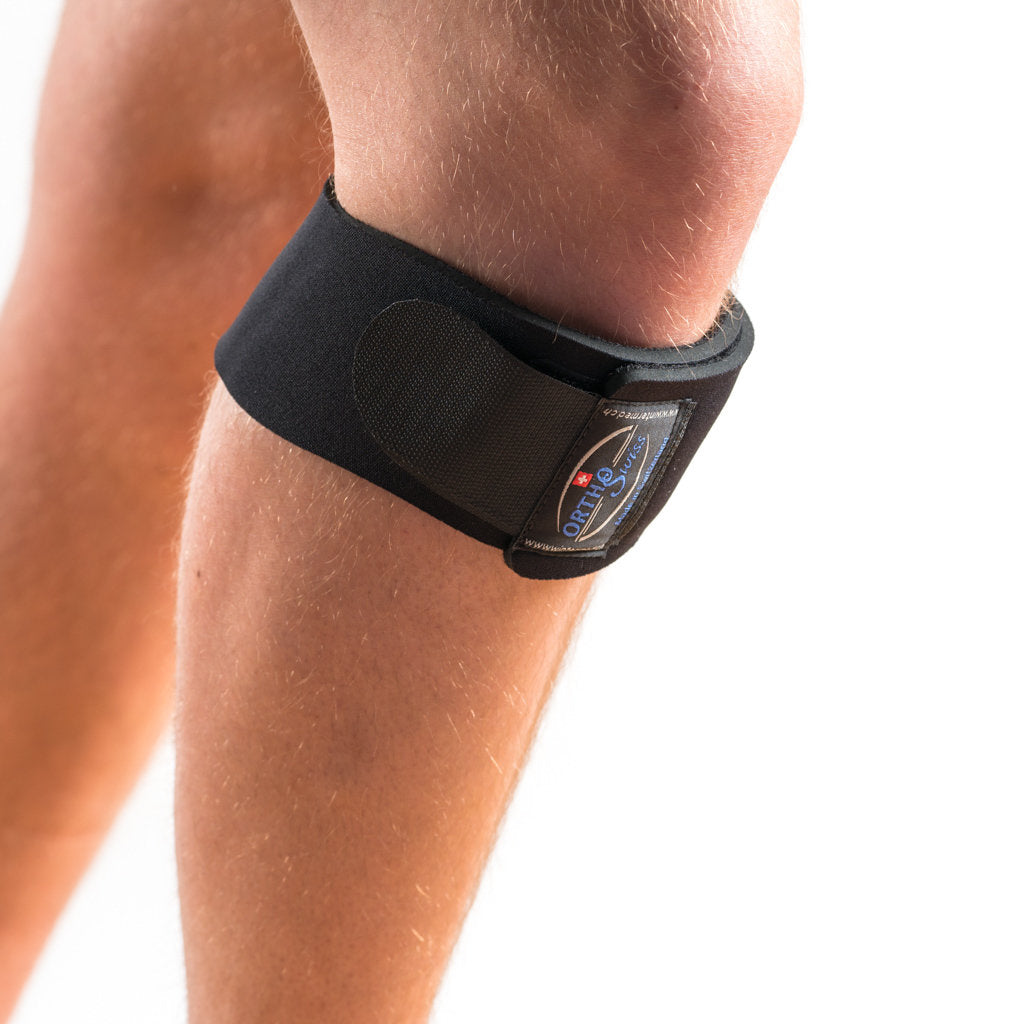 Orthoswiss Mini Kniebandage in Schwarz unterhalb der Patella, Bein leicht nach vorn gestellt. 