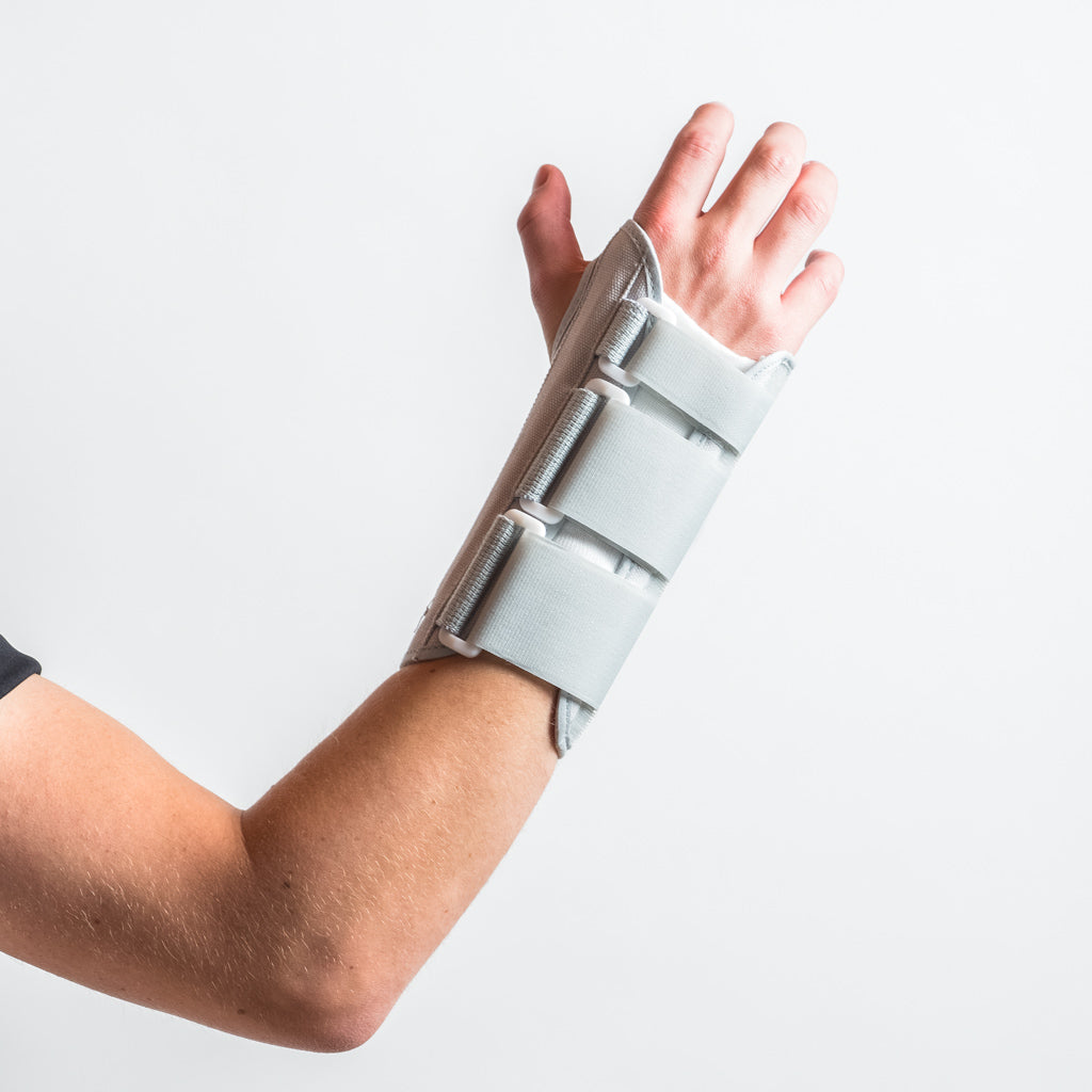 Graue Eclipse Wrist Brace Handschiene am Handgelenk, Arm leicht angewinkelt, Hand erhoben und nach aussen gedreht.