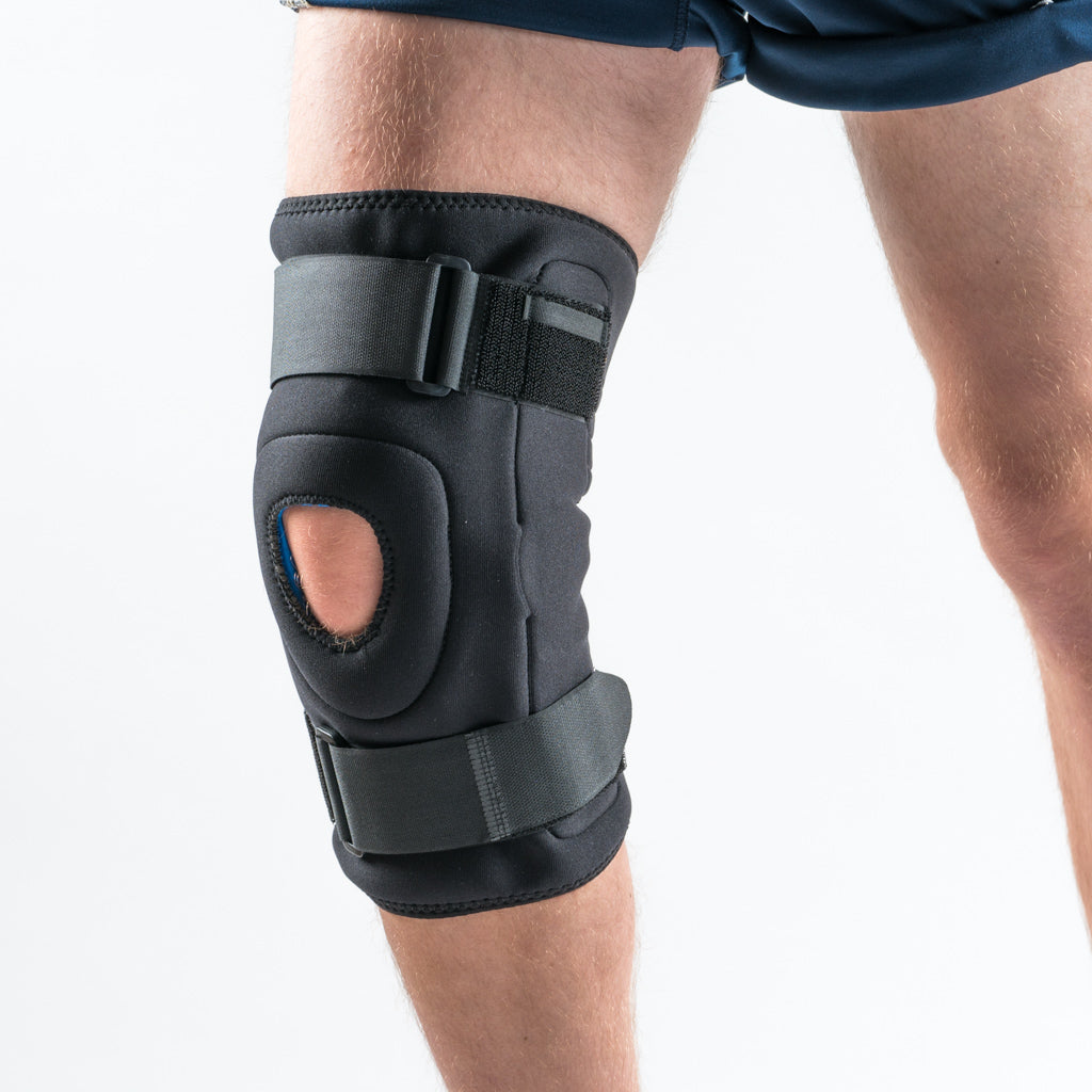 Vorderansicht der NEOMAX Kniebandage am rechten Bein, schwarze Bandage mit Alu-Gelenken und offener Patella. 