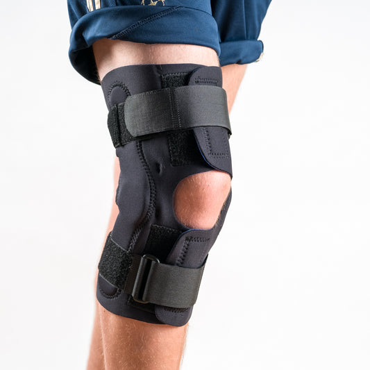 Wrap Around Kniebandage in Schwarz am rechten Bein, Seitenansicht, leicht angewinkelt
