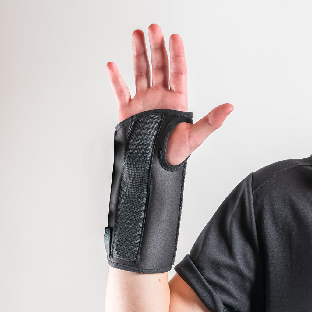 Formfit Handgelenkschiene in Schwarz, Arm erhoben, Handfläche offen nach vorne, Finger leicht gespreizt.