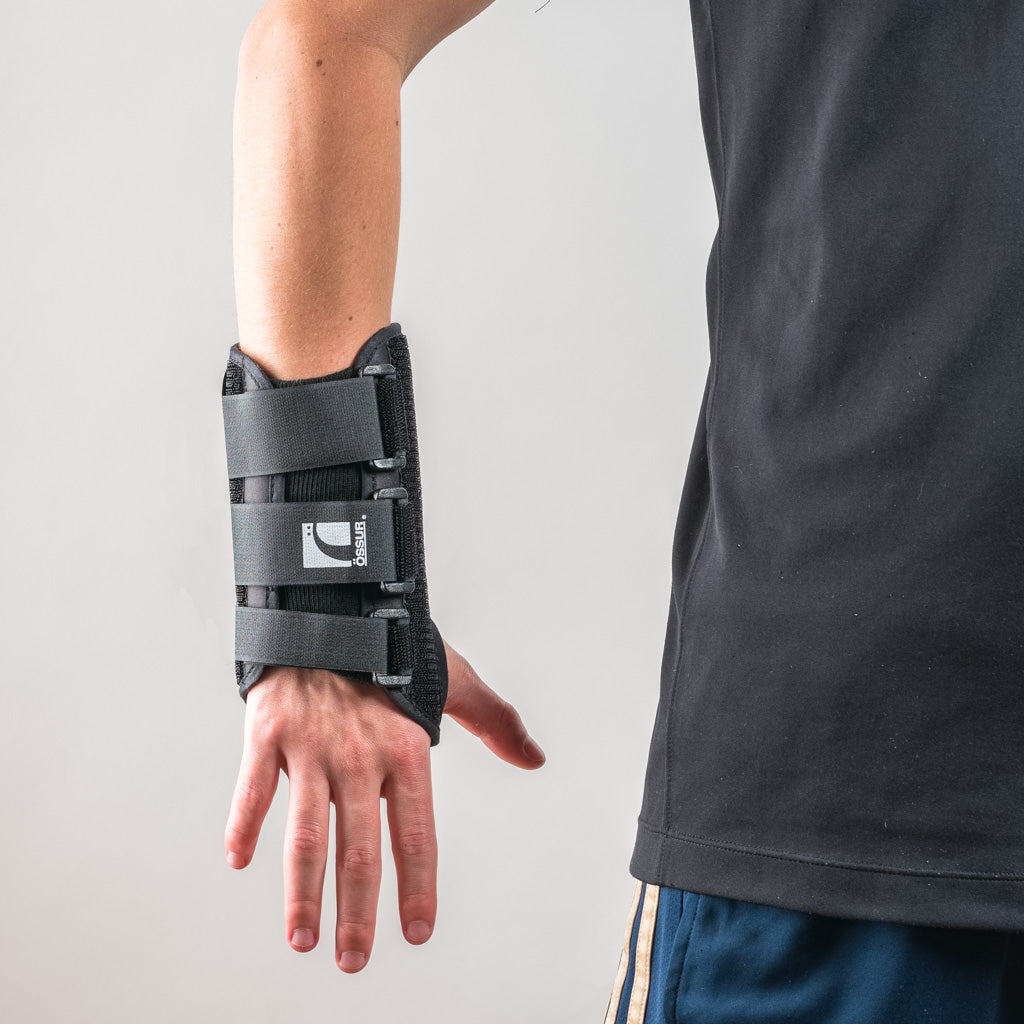 Formfit Handgelenkschiene in Schwarz, Arm hängt locker seitlich, Hand entspannt nach unten gerichtet.